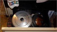 Stove drawer contents:  baking items & lids