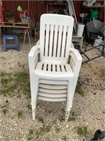 stack of white plastic lawn chairs