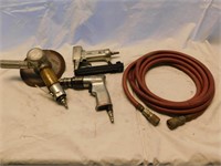 3 air tools with air hoses.