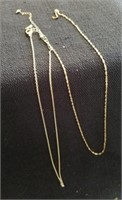 Two gold colored necklaces one looks like it