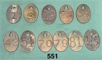 Eleven brass tags with numbers on them