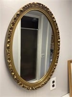 Oval golden colored hanging mirror