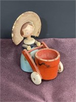 Vintage wood figurine lady pushing basket