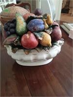 A bowl of ceramic fruit that sits on the dining