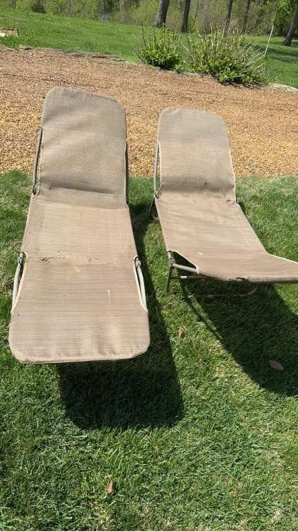 A set of lounge chairs and umbrella stand