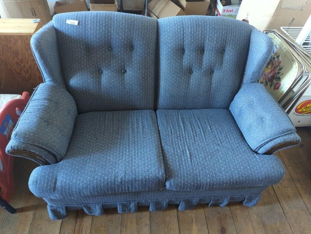 Blue loveseat shows signs of wear