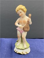 Boy playing instrument figurine