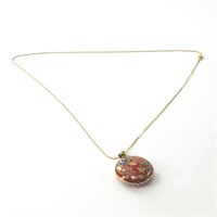 Red enameled pendant, on a gold tone chain, 24" ci