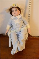 PORCELAIN DOLL IN WICKER CHAIR