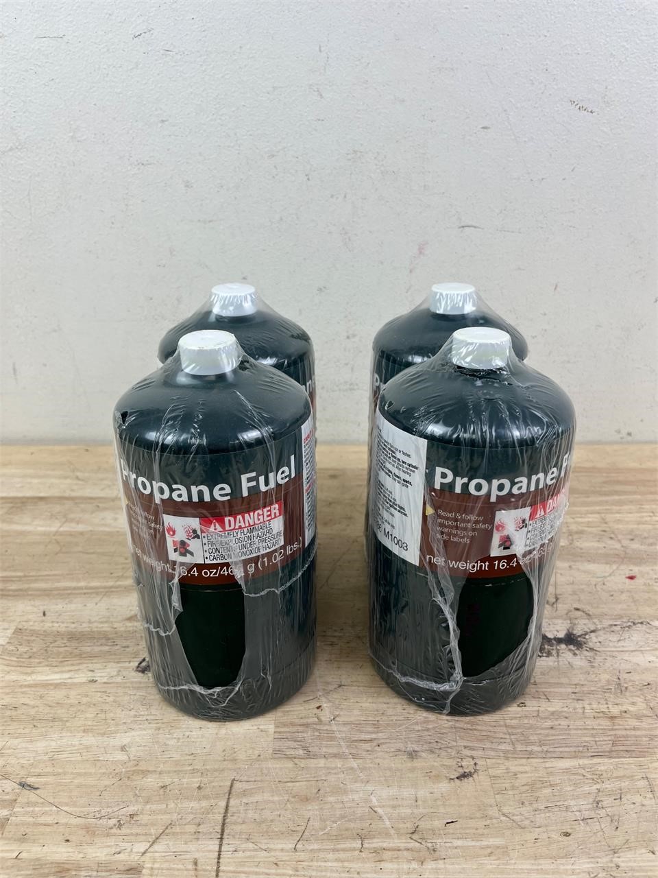 Four small unused propane fuel bottles