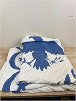 Blue and white eagle quilt with some stains