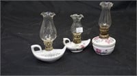 Three decorative oil lamps.
