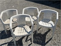 Four white plastic outdoor chairs