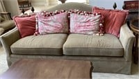 Plush sofa with accent pillows and finial back