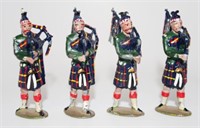 Four metal models of highland pipers