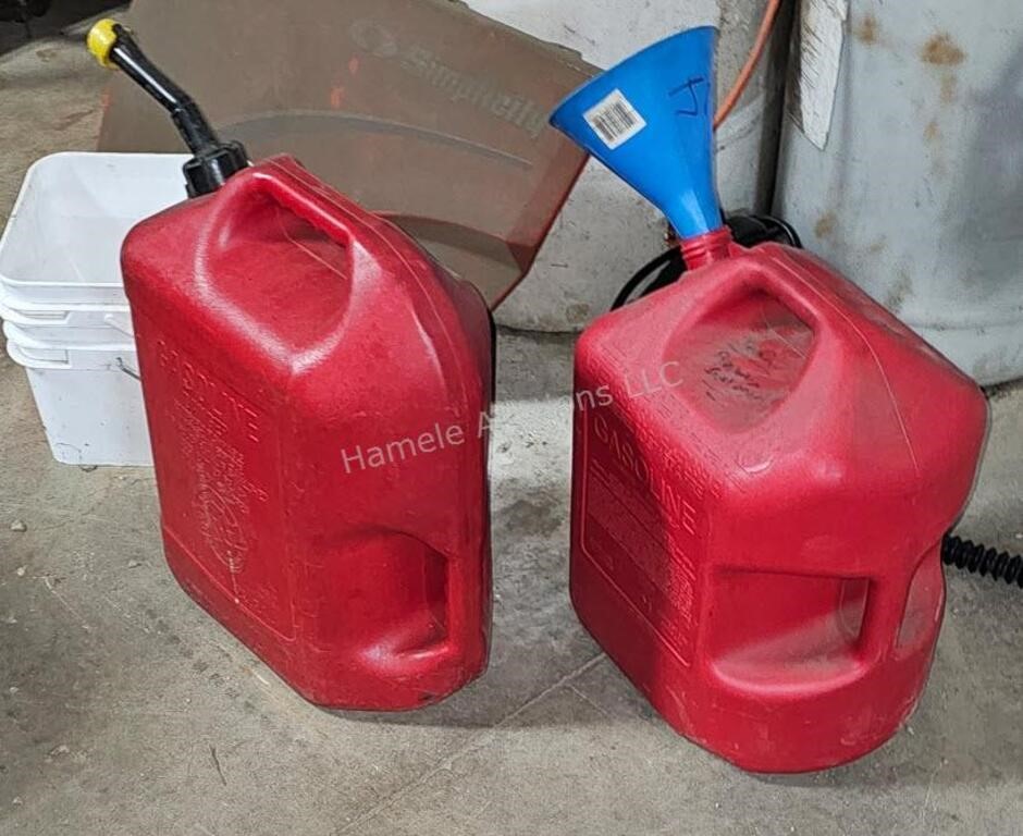 4 plastic gas cans - some with contents - in shop