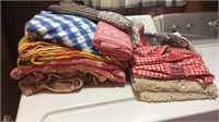 Assorted table cloths, rug, towels