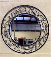 Round beveled mirror in a round metal frame with