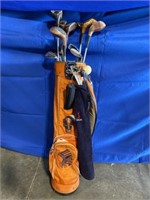 Orange golf bag with woods, putters and wedges of