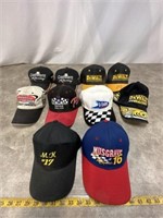 Assortment of racing hats, some are signed