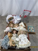 Variety of porcelain dolls, doll clothes, and