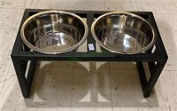 Elevated dog dish holder with two dog dishes.