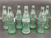 Seven Empty Coca Cola Glass Bottles