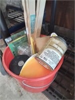 Red plastic bucket with painter stir sticks and