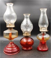 3 VINTAGE RED GLASS AND CLEAR GLASS OIL LAMPS