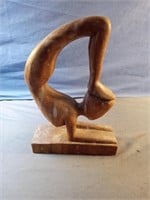 Wood carved figure doing yoga pose