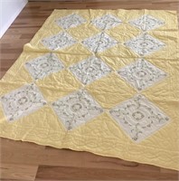 Yellow and white hand stitched quilt