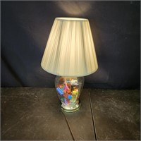 Glass table lamp, filled with small plastic toys