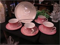 Four red and white cups and saucers marked The
