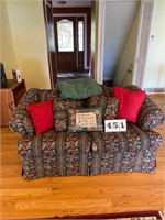 Loveseat with throw pillows and blanket