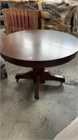 Round wooden dinner table with 3 extra leaves