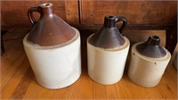 Three stoneware jugs, the smallest is missing the