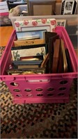 Pink crate  filled with picture and photo frames