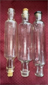 Three glass rolling pins, two with cork and one