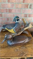 Two carved wood duck decoys, one mounted on a