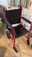 One red push wheelchair, with double brakes on