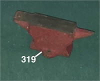 Small red anvil with two holes at base for screwin