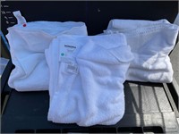 Three white towels, one with tags