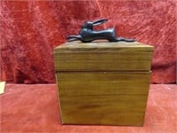 Cast rabbit figure on wood box.