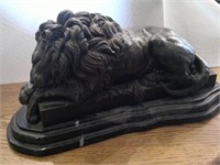 bronze sleeping lion on marble stand