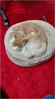 Realistic toy cat in bed