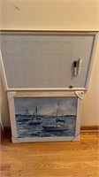 Dry erace board & a blue and white sailboat