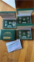 Four green boxes of collector coins, national
