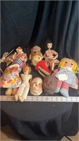 Box of misc dolls, faces, and wooden puppet