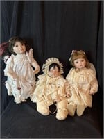 3 porcelain dolls one has broken hand
