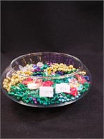 Container of Mardi Gras beads and four